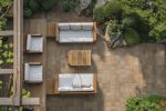 Aerial shot of wooden deck with sand patterns, furniture, and plants. AI generated